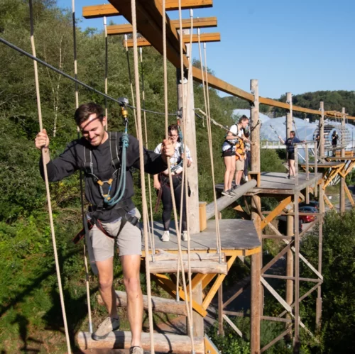 A large group adventuring on sky trek the treetop obstacle course at hangloose eden